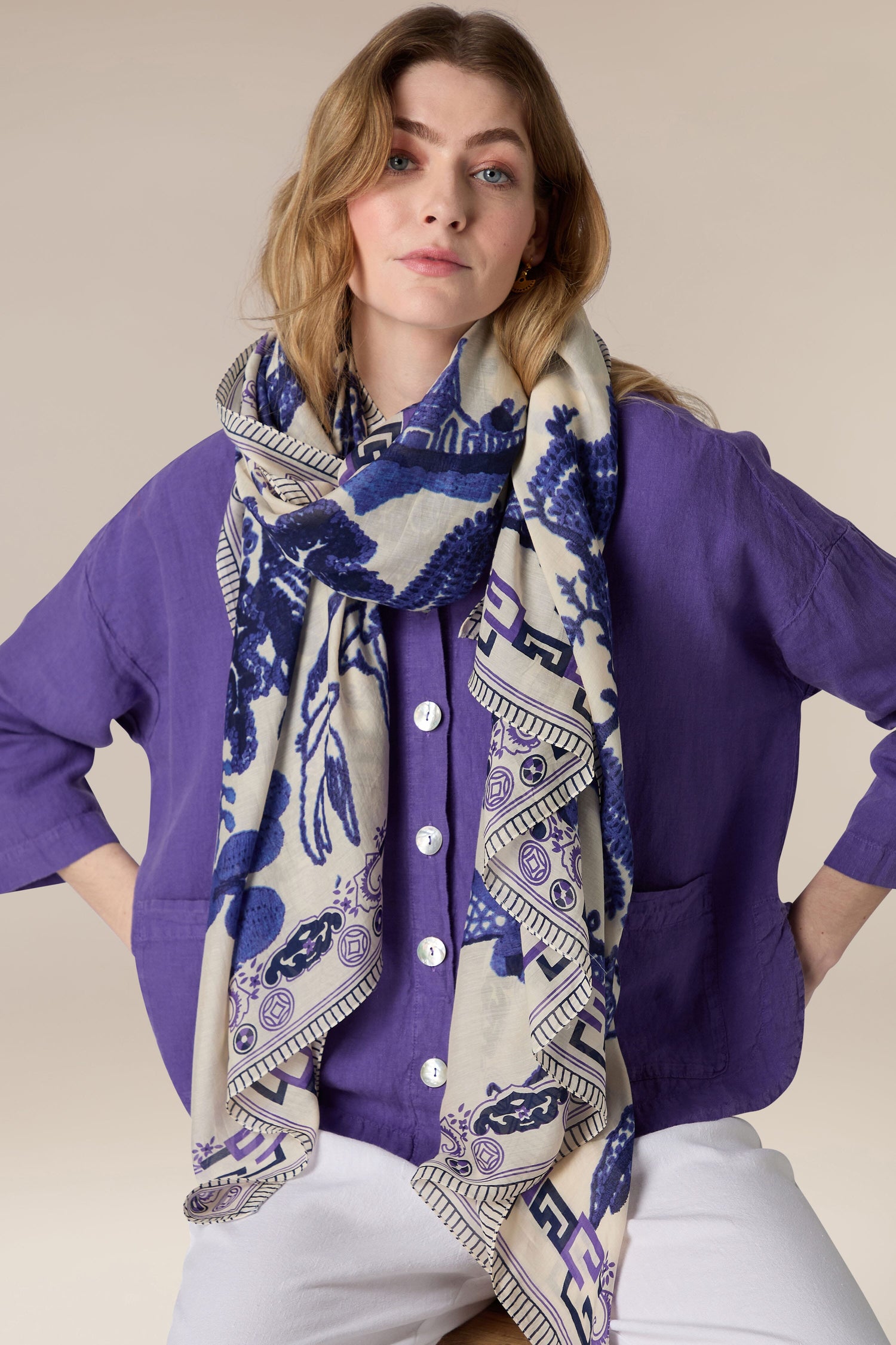 Woman wearing a purple shirt and a Pashmina Scarf with hands on hips.