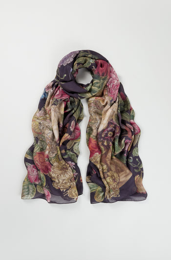 The Primula Scarf, featuring a floral print in shades of purple, green, and pink, is displayed flat on a white background—a stylish accessory to elevate your everyday look.