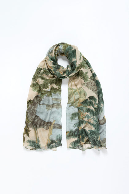 The Rivers and Trees Print Scarf features a lightweight design with a beige background and watercolor-style trees and greenery, showcased on a white surface.