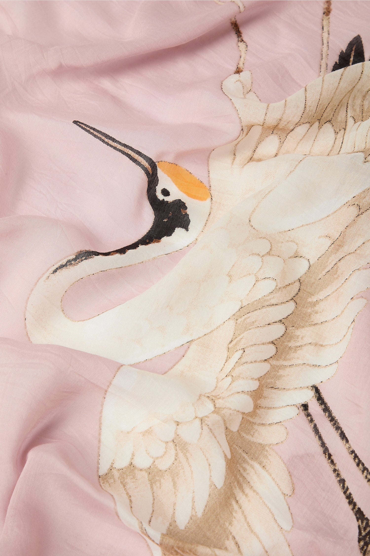 Embroidered stork design on a pink modal fabric.