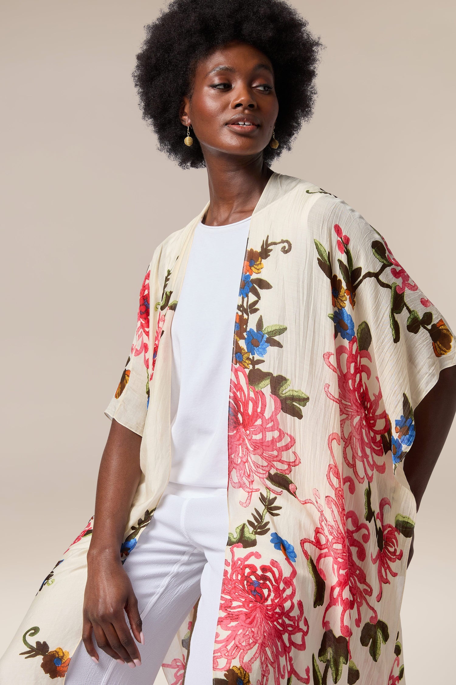 A black woman wearing a Chrysanthemum Throwover as a beach cover-up.