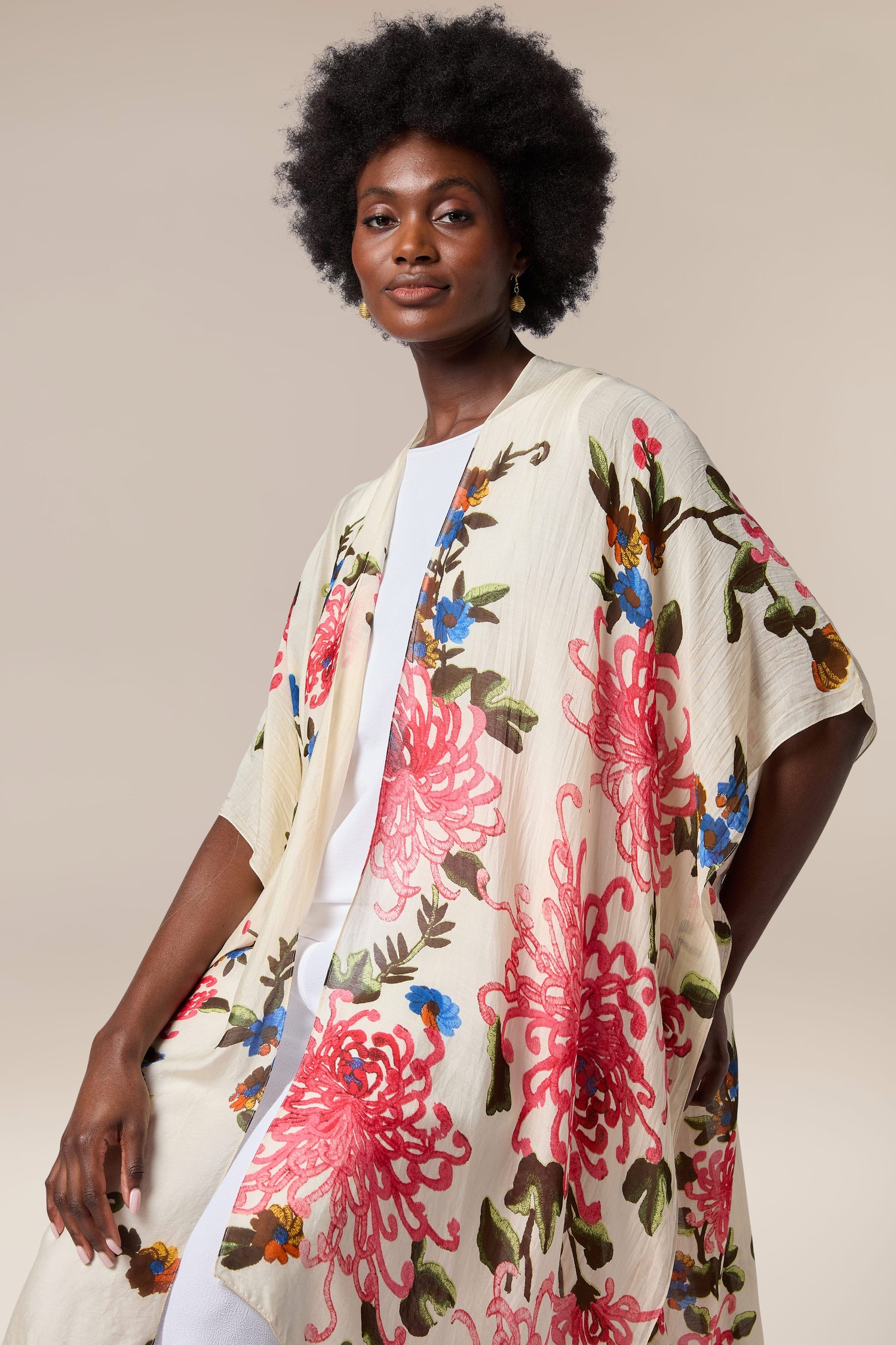 A black woman wearing a Chrysanthemum Throwover by One Hundred Stars, serving as a throwover or beach cover-up.