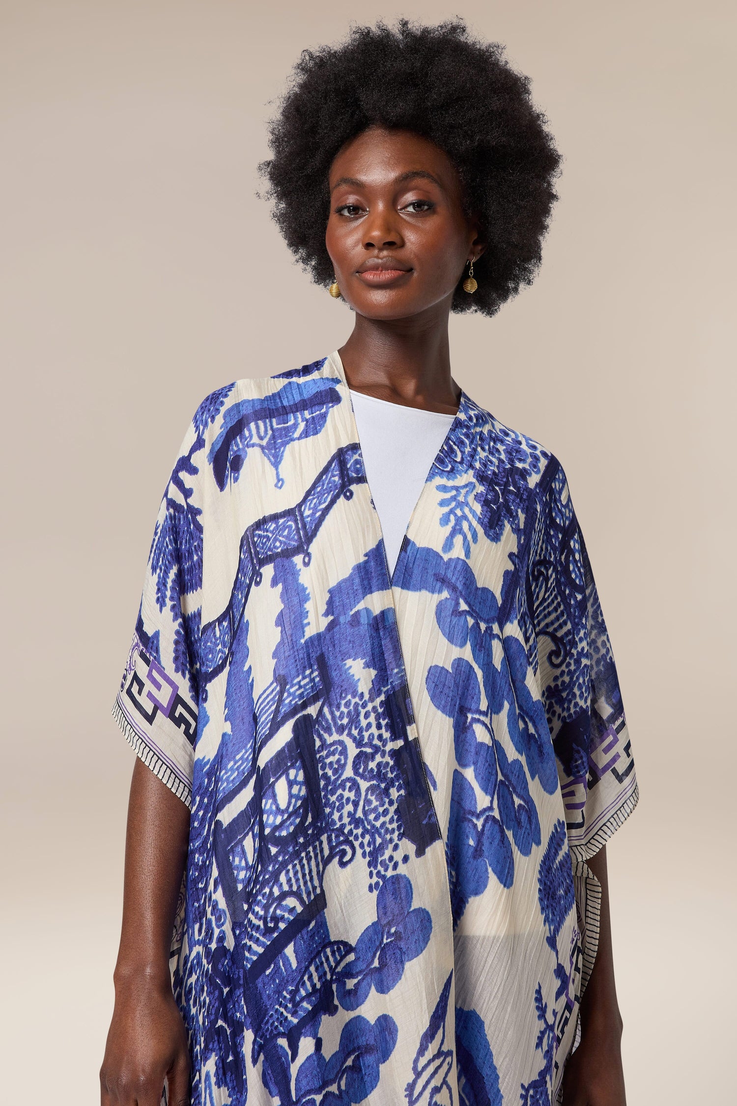 An Indian woman wearing a blue and white printed Willow Throwover, a traditional textiles throwover.