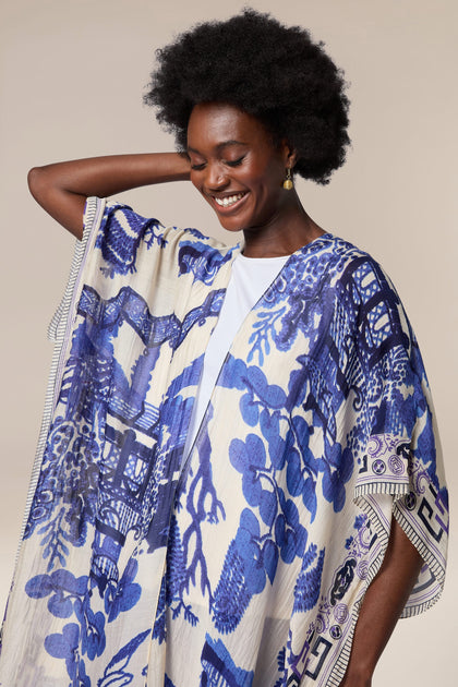 A woman wearing a blue and white Willow Throwover, a graceful traditional throwover garment.