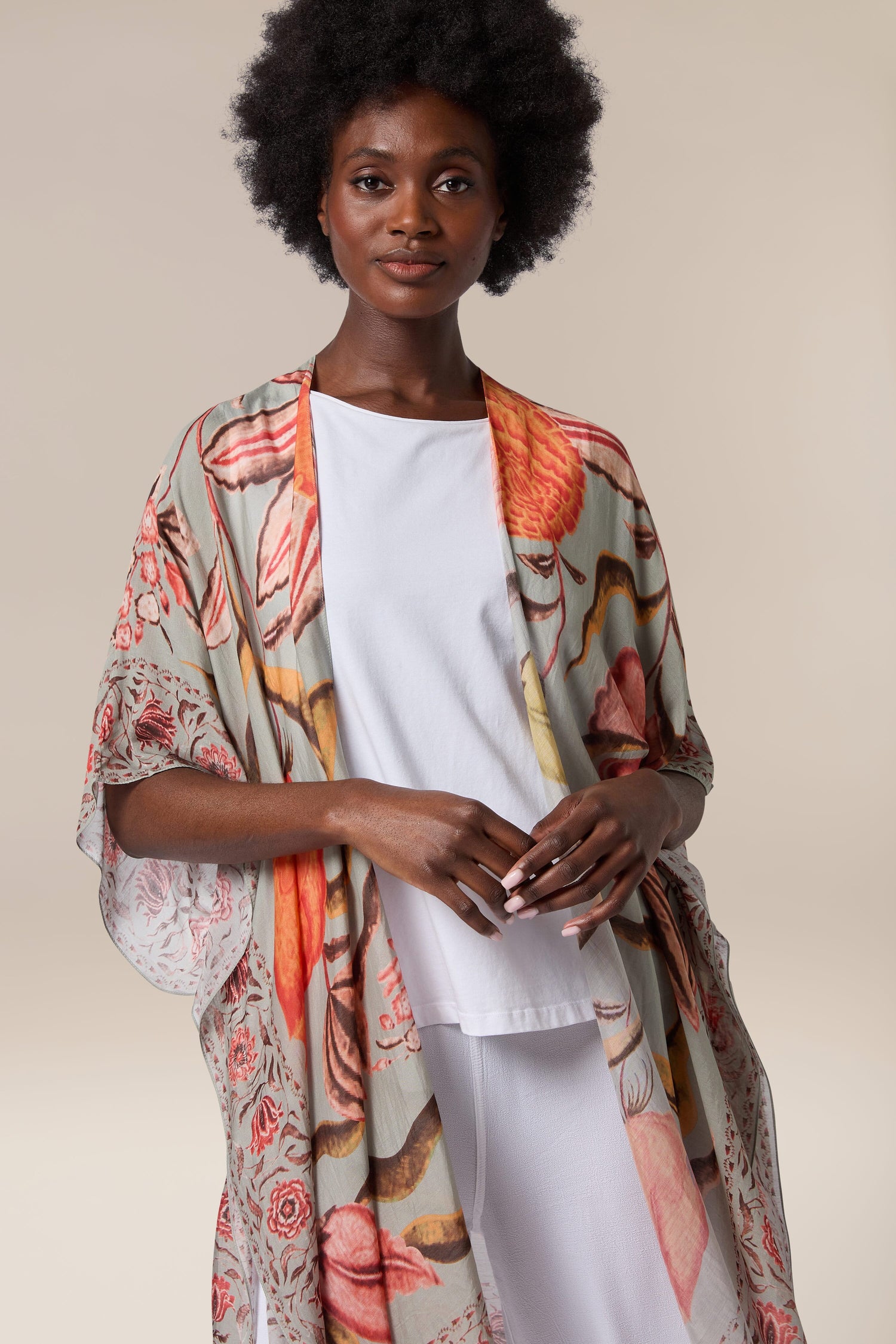 A woman wearing a Joy Throwover adorned with a floral pattern from India.