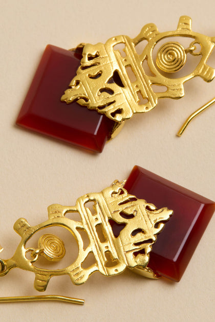 Close-up of Gold-Plated Carnelian Drop Earrings featuring geometric gold designs and square carnelian stones on a neutral background.