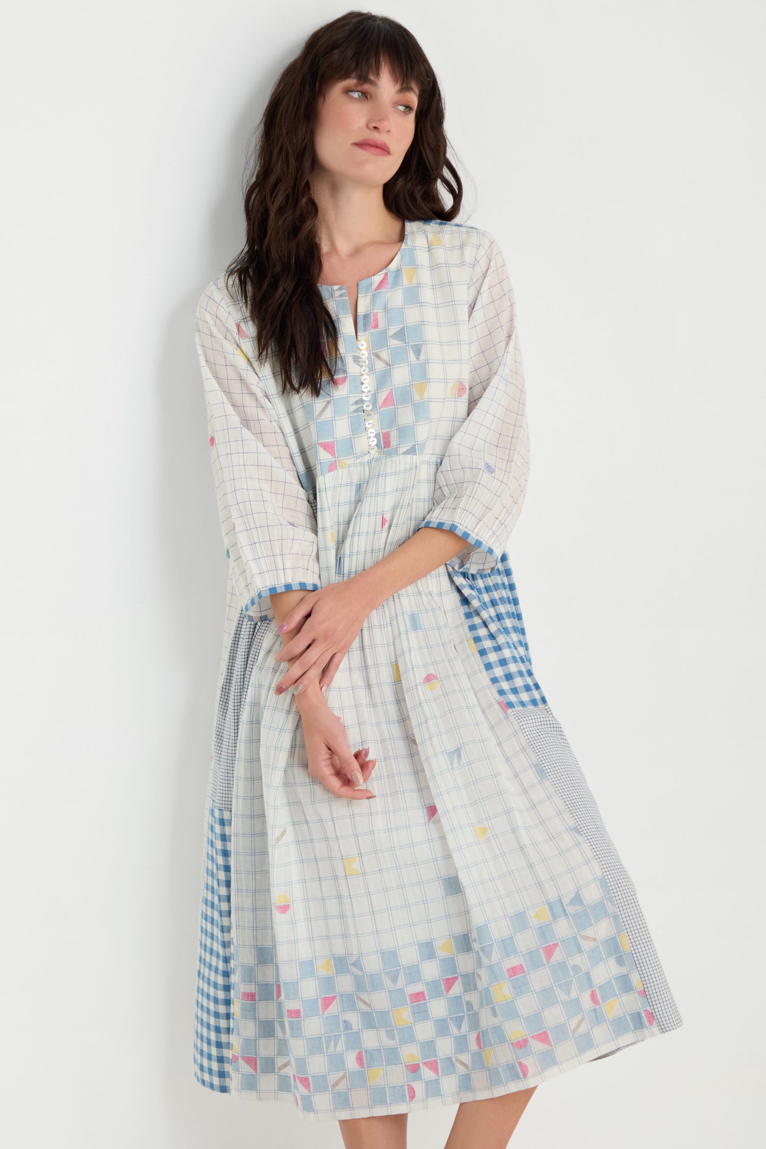 A woman models the Jamdani Check Dress—midi-length, pure cotton with pastel checkered and geometric patterns—against a plain white background.