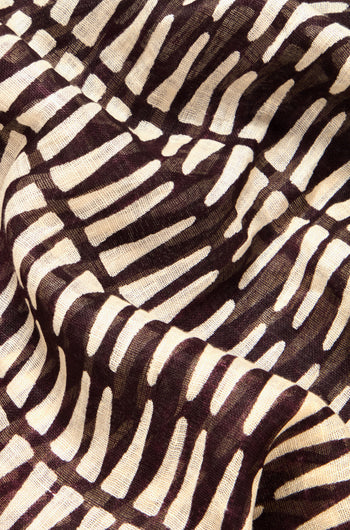 Close-up of the versatile Printed Linen Mix Woven Scarf, showcasing abstract dark brown and light cream curved lines on a slightly wrinkled linen-cotton blend, enhancing texture.