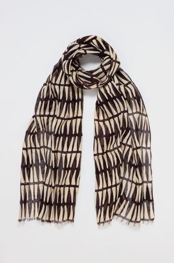 The Printed Linen Mix Woven Scarf is a versatile accessory, featuring black and white vertical and horizontal patterns on a textured linen-cotton blend, set against a plain white background.