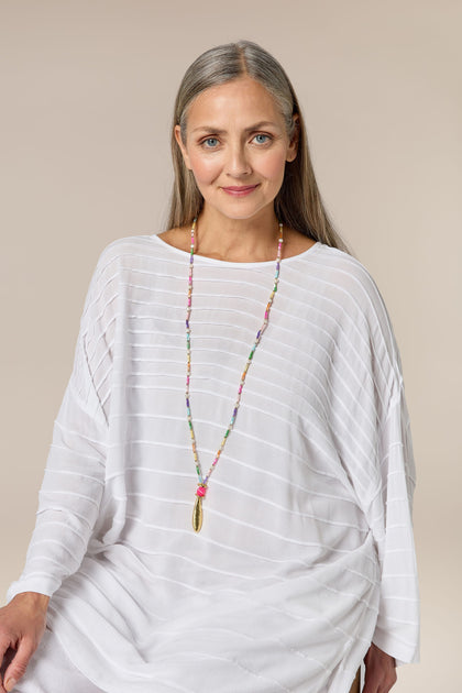 A woman wearing a vibrant Sherbet Beaded Pearl Pendant necklace.