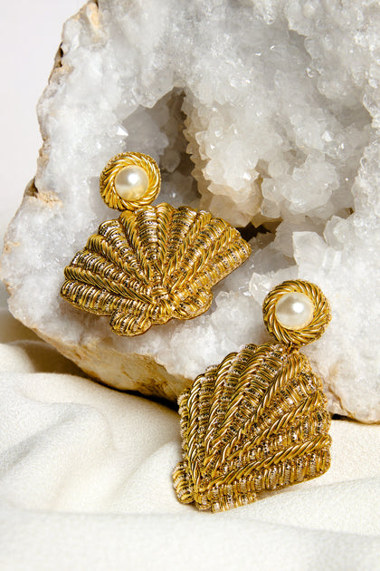 The Hand Embroidered Golden Shell Glass Pearl Earrings feature exquisite pearl accents and are set against a large crystal rock for a striking display.