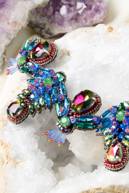 A bold and colorful hand-beaded necklace with hand-beaded beads on top of a rock, creating a stunning statement piece that adds sparkle to any outfit.