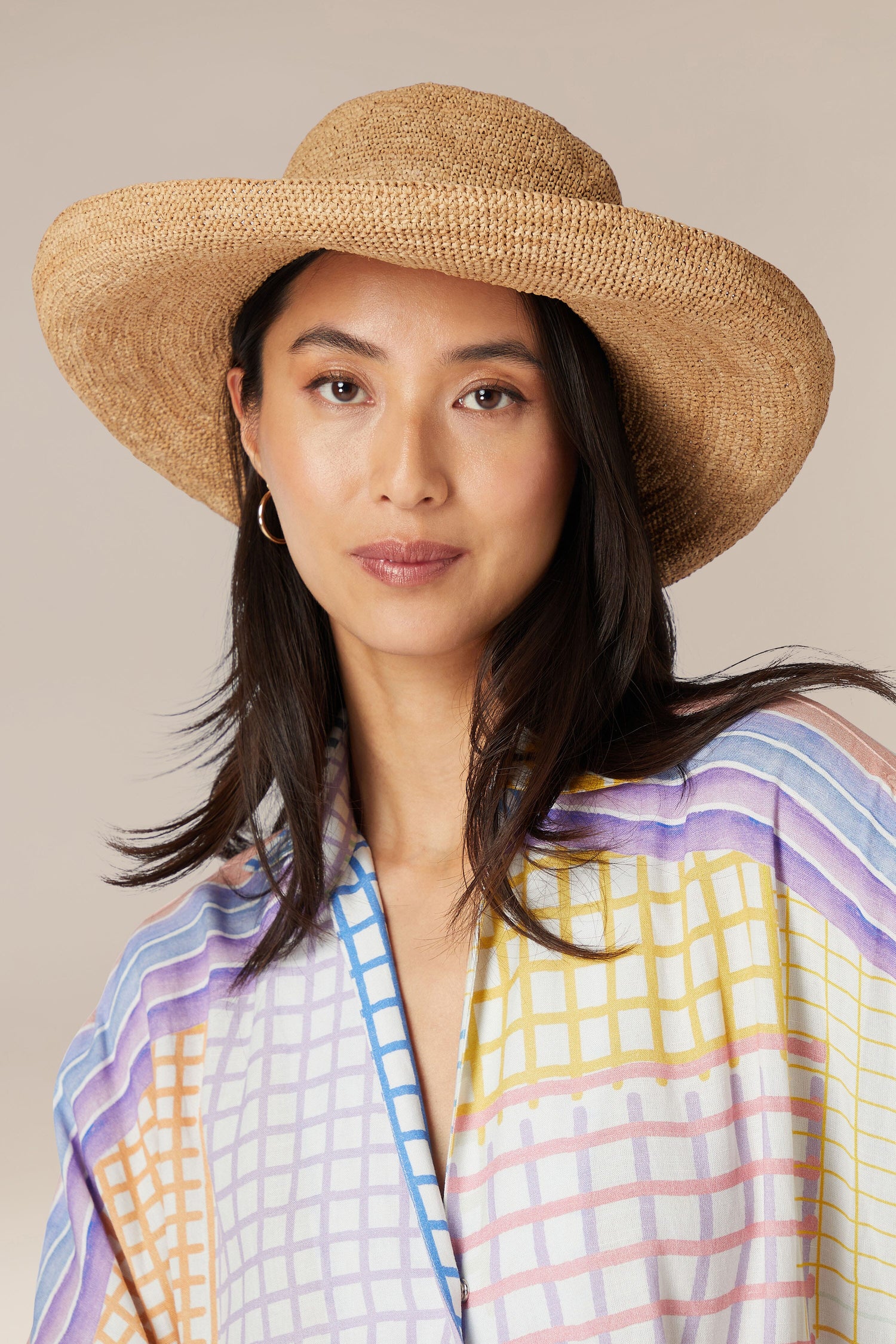 Woman wearing a Wide Brim Woven Raffia Hat and patterned shirt.