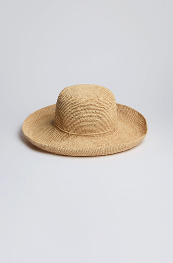 The Handwoven Wide Brim Raffia Hat sits elegantly on a plain white background, offering stylish sun protection.