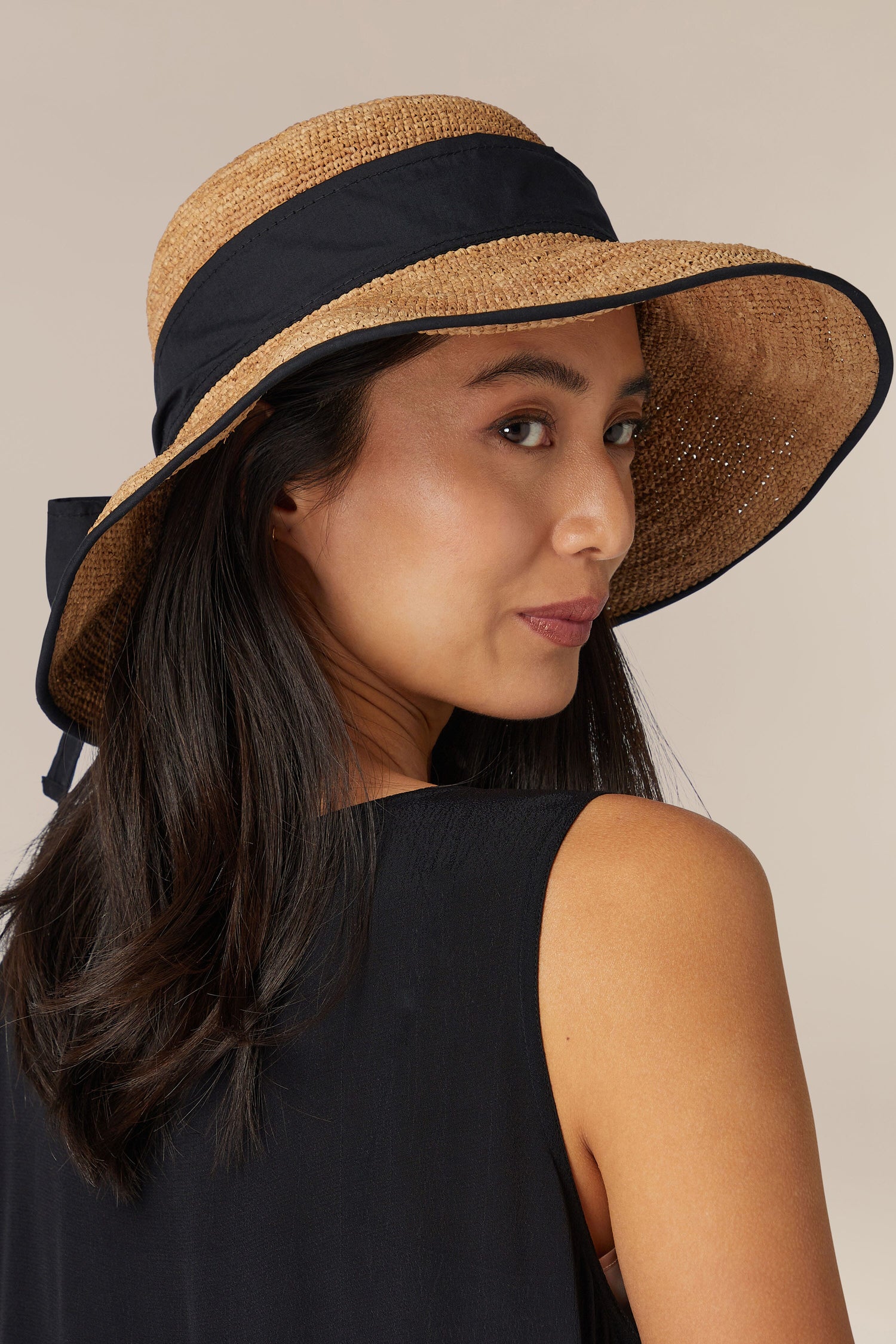 Woman wearing a hand-crafted Wide-Brimmed Ribbon Raffia Hat from Madagascar.