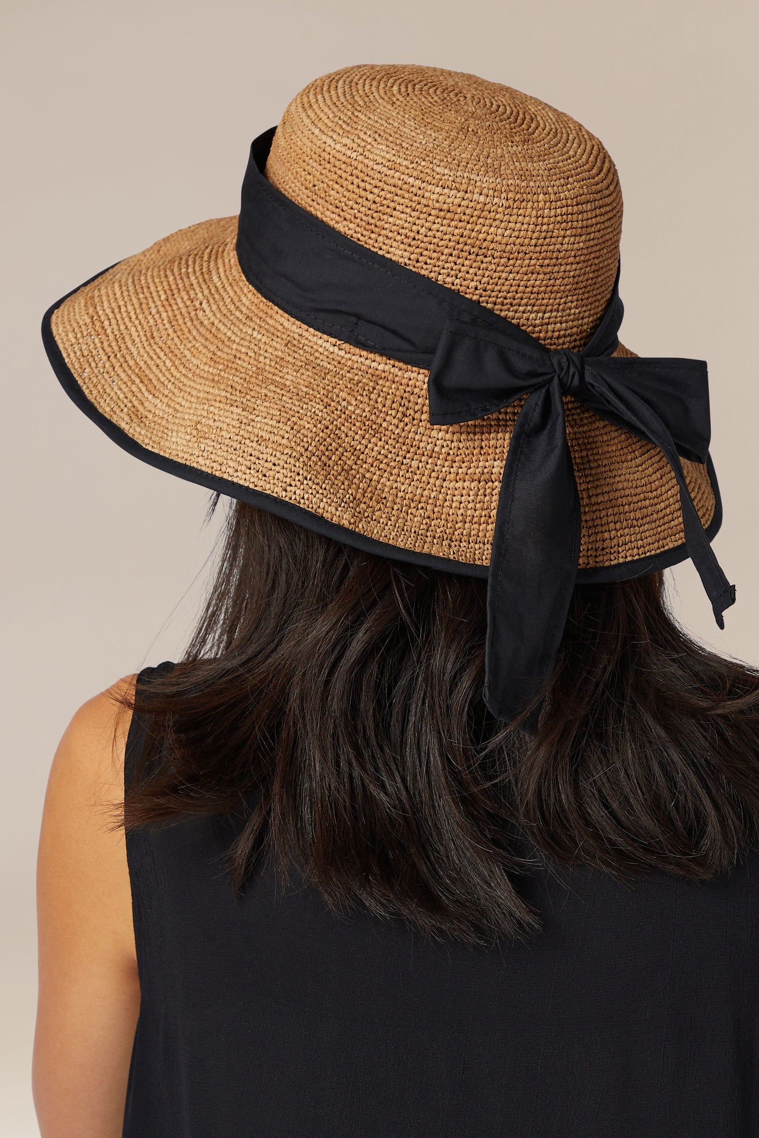 Woman wearing a wide-brimmed Ribbon Raffia Hat viewed from behind.