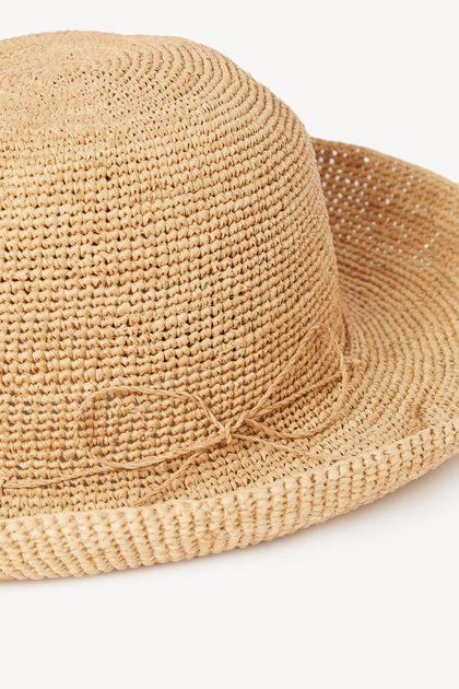 Close-up of a woven Raffia Hat with a bow detail.