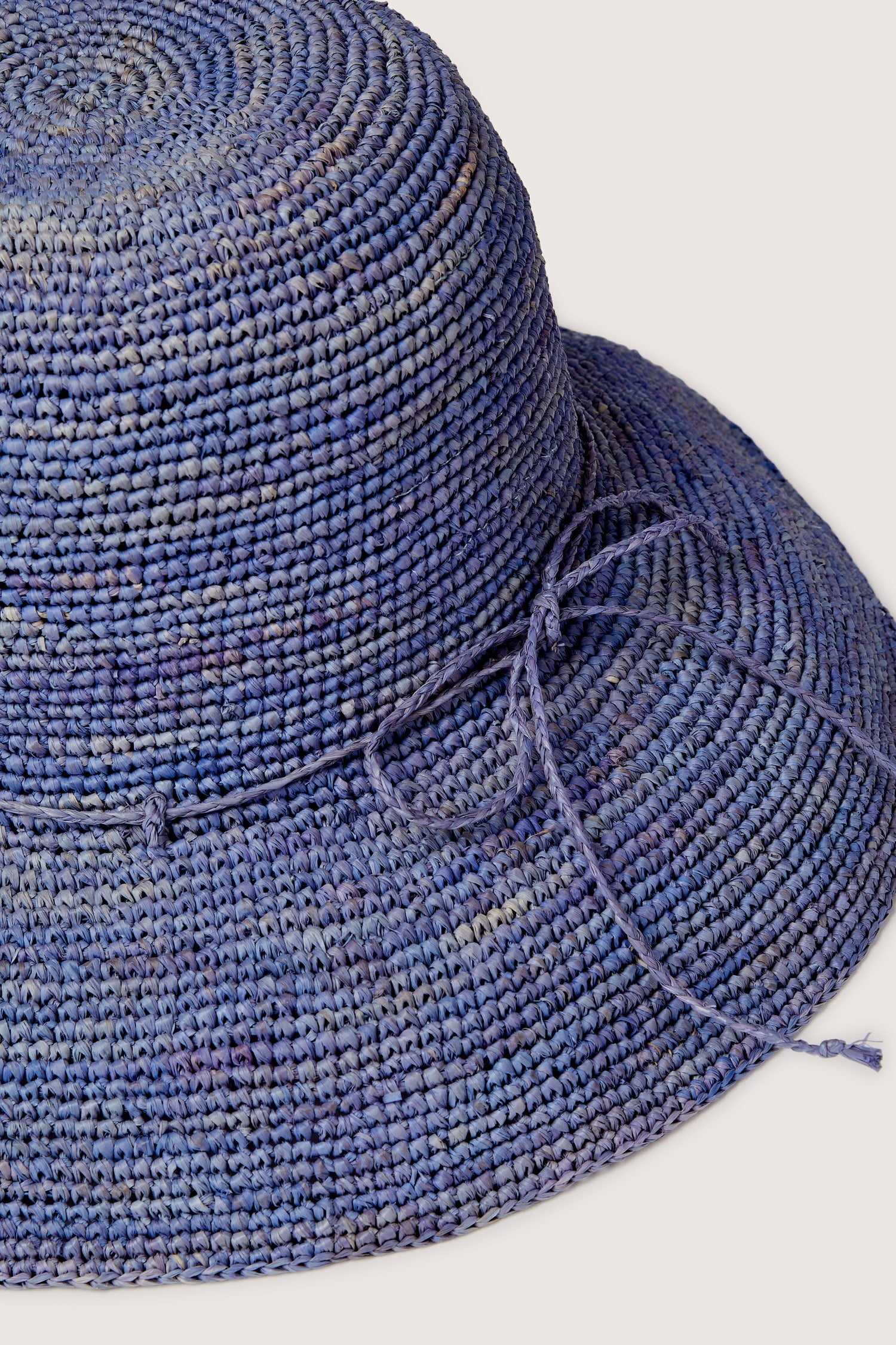 Close-up of a textured blue Raffia Hat with a matching drawstring, displayed against a light background.