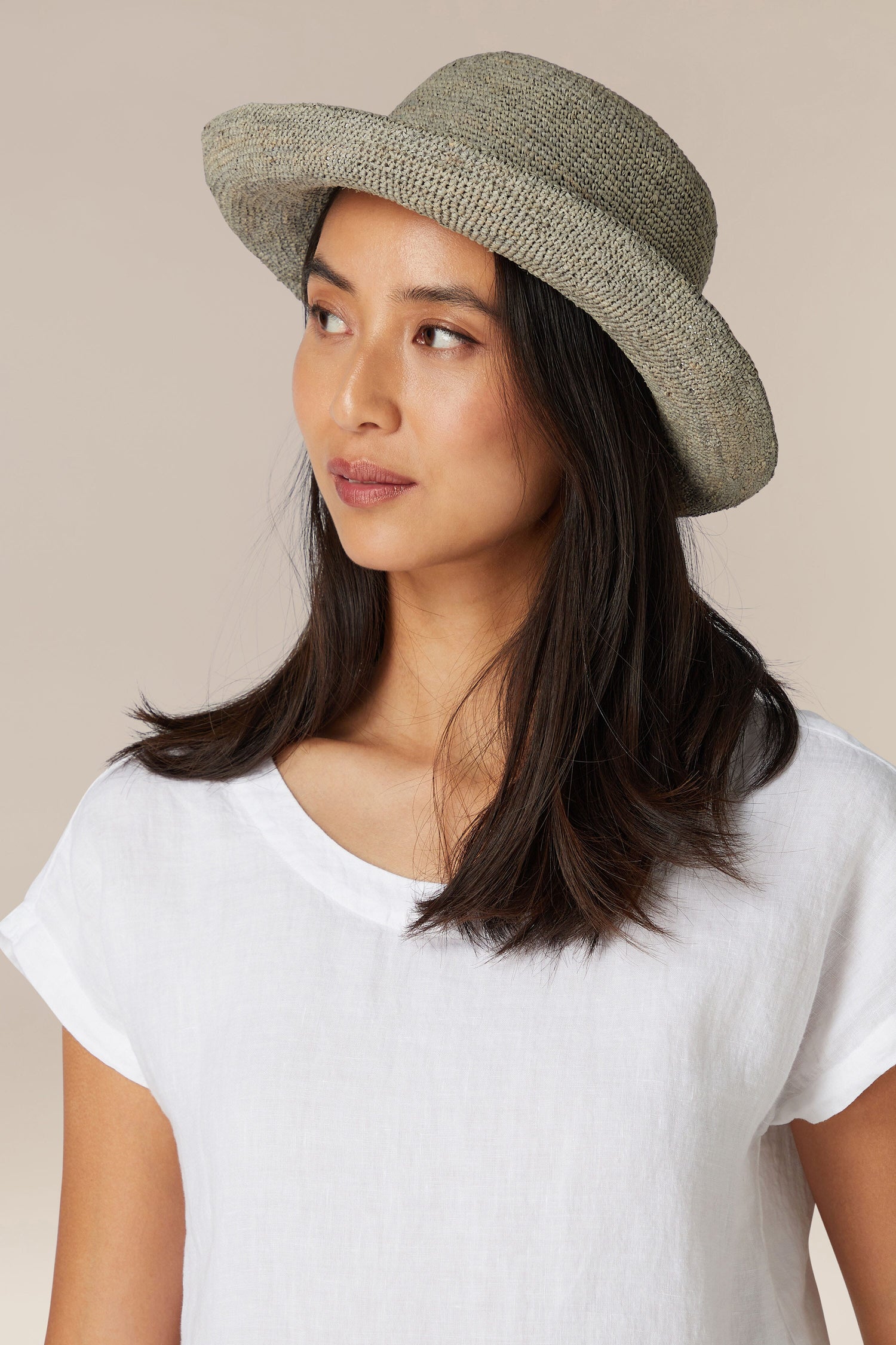 A woman wearing a Woven Raffia Hat and a white t-shirt.