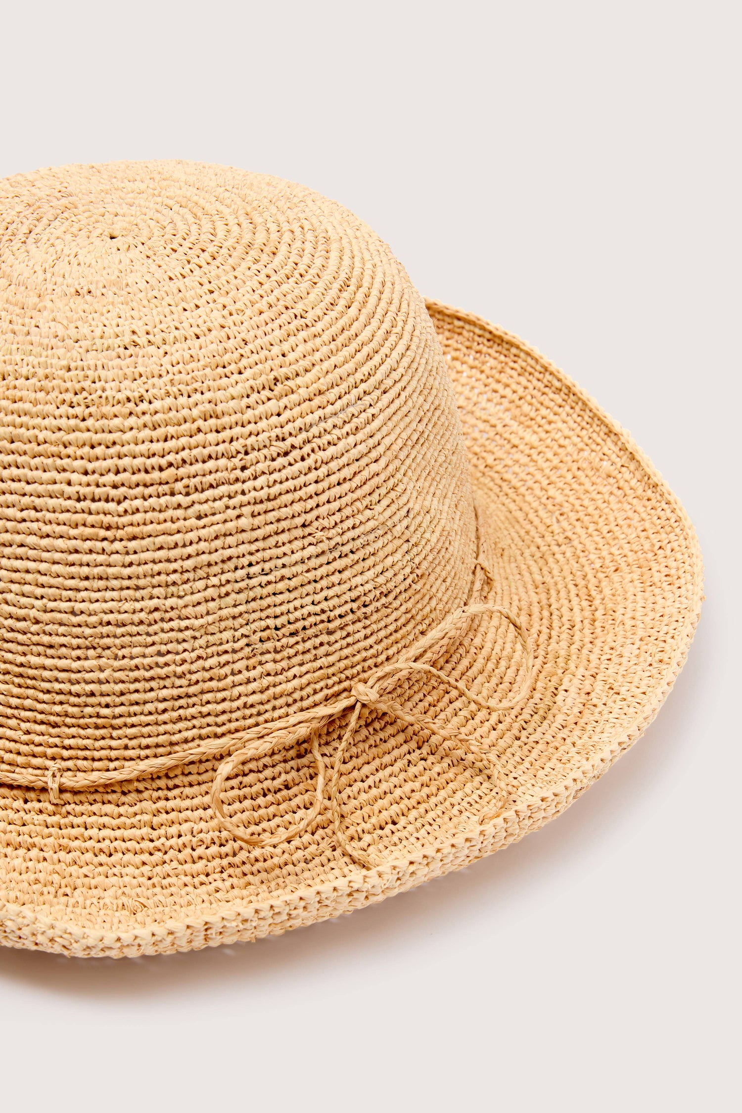 Woven Raffia Hat with a wide brim and drawstring against a neutral background, made of lightweight, breathable raffia from Madagascar.