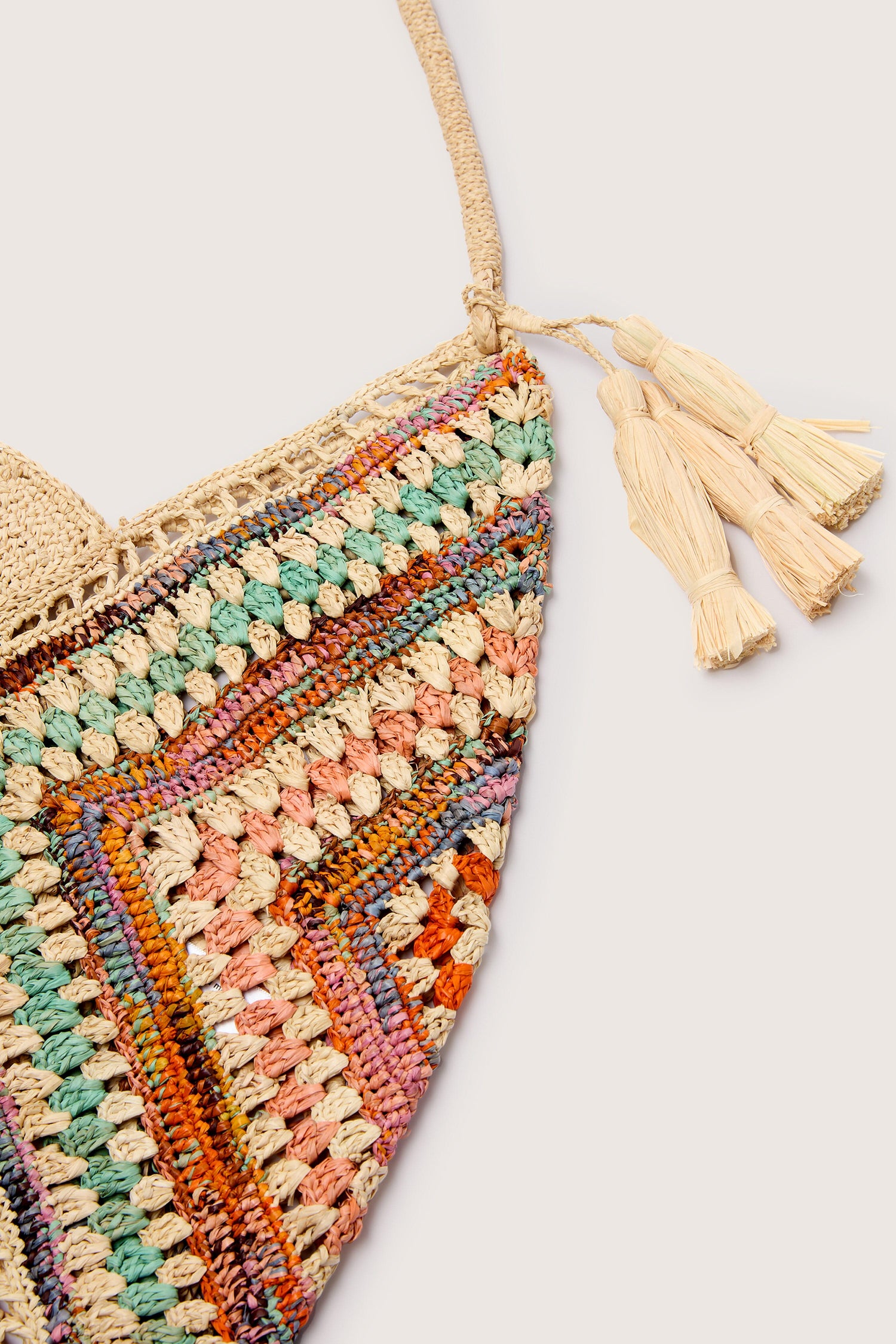 Woven Bohemian Raffia Bag with tassel detail on a white background.