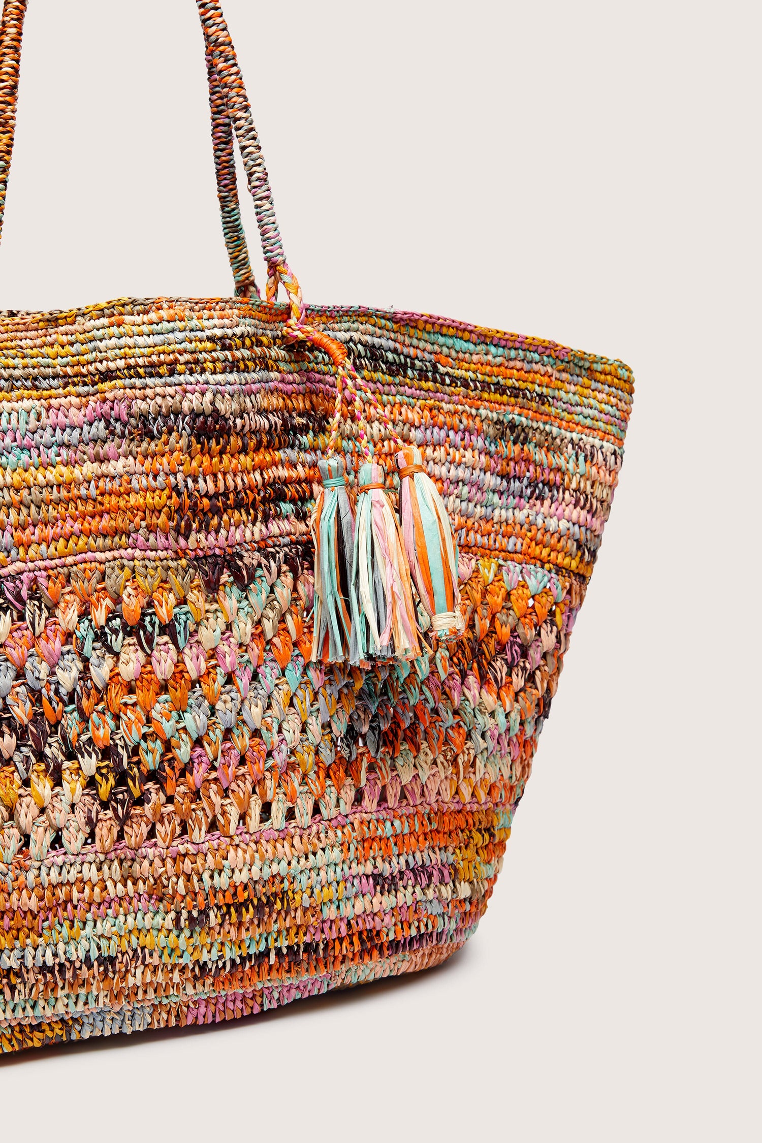 Woven Rainbow Raffia Bag with tassel detail on a white background, made by Madagascar artisans.