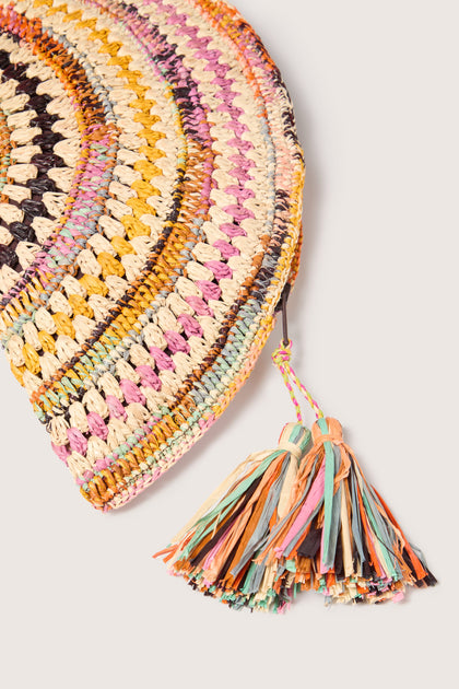 Madagascar hand-crafted Woven Half Moon Raffia Clutch with a tassel detail on a solid background.