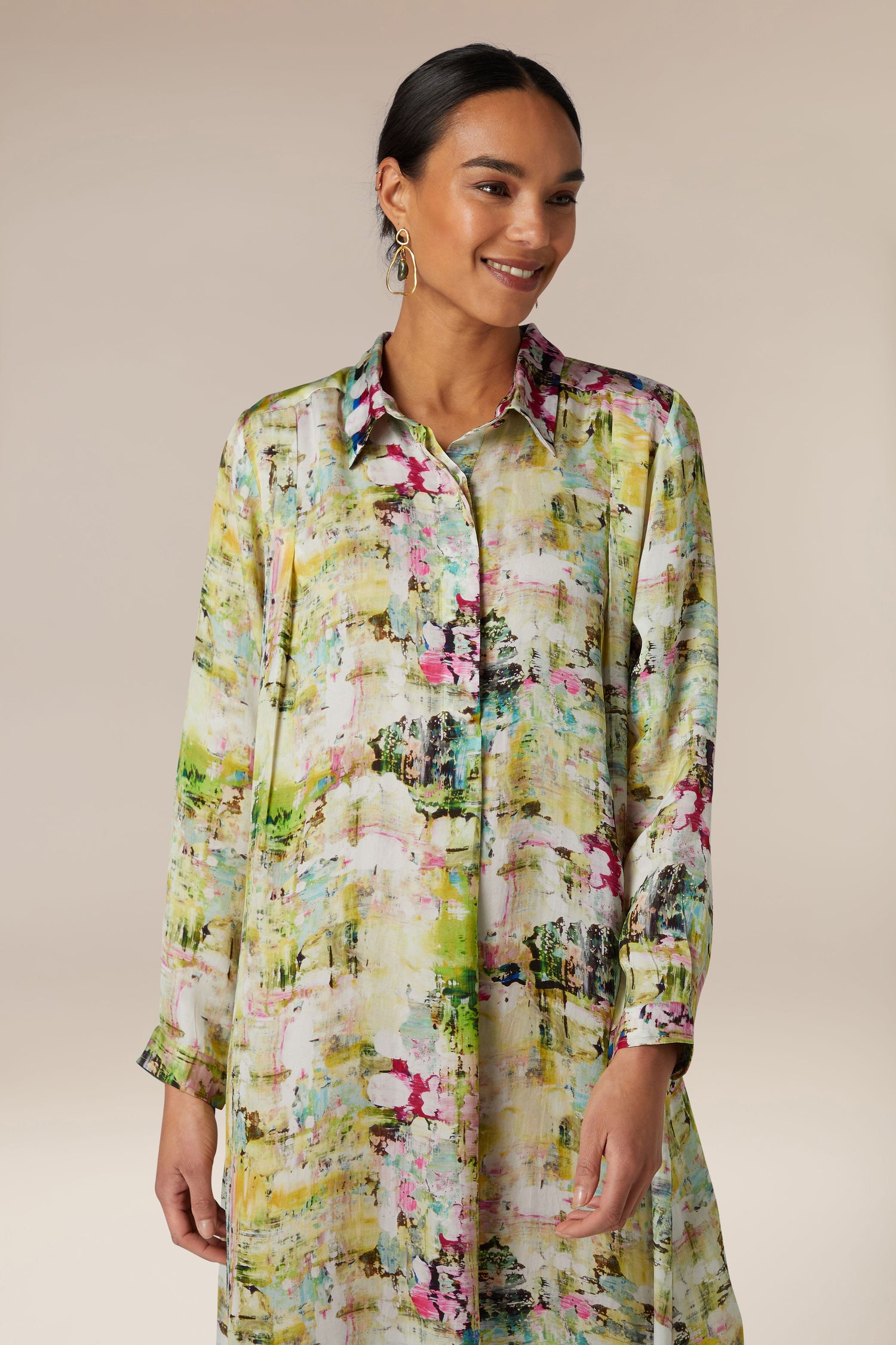 A woman wearing a cupro fabric, Pelia Button Front Dress with a floral printed pattern.