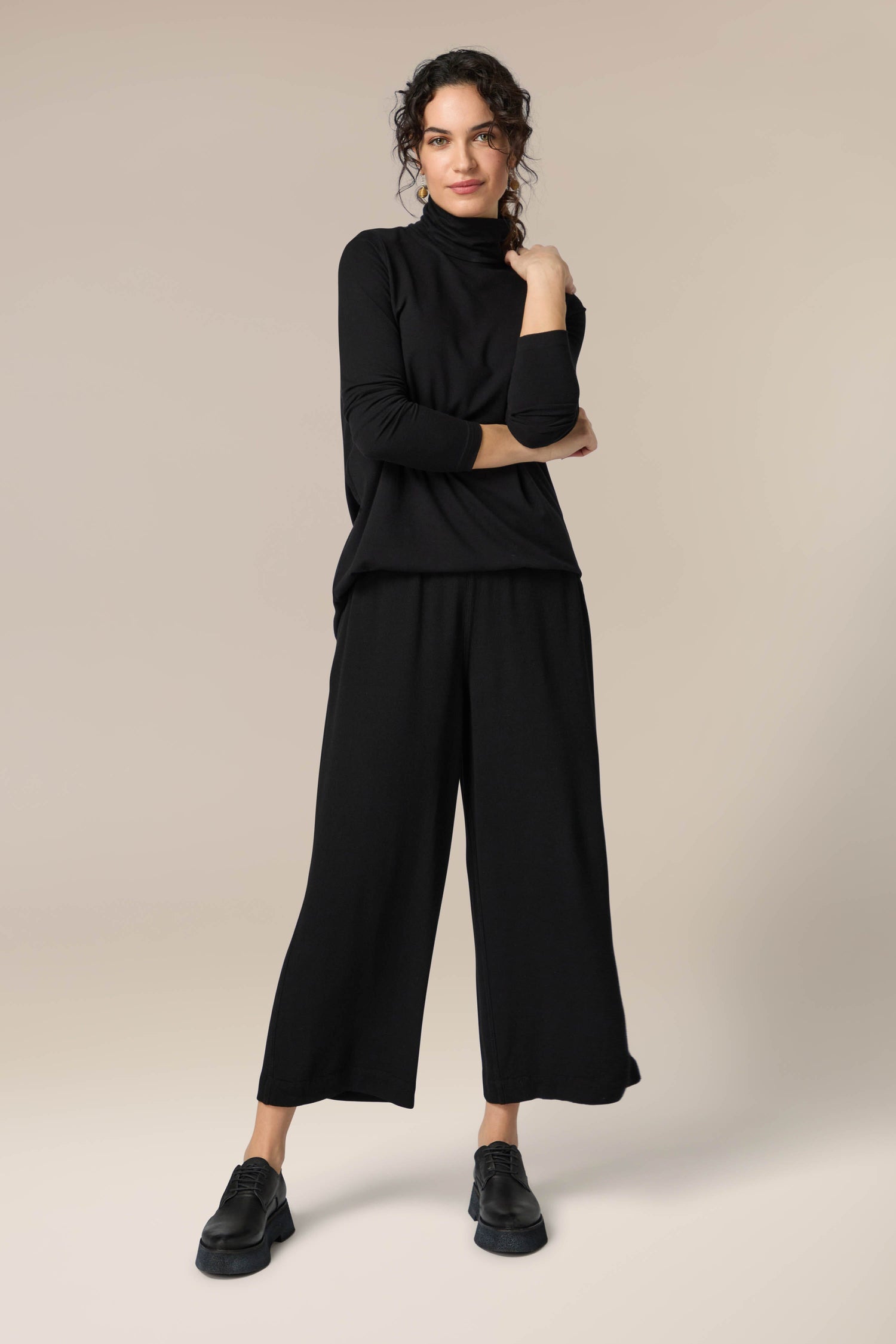 A woman donning Crepe Wide Trouser with an elasticated waist.