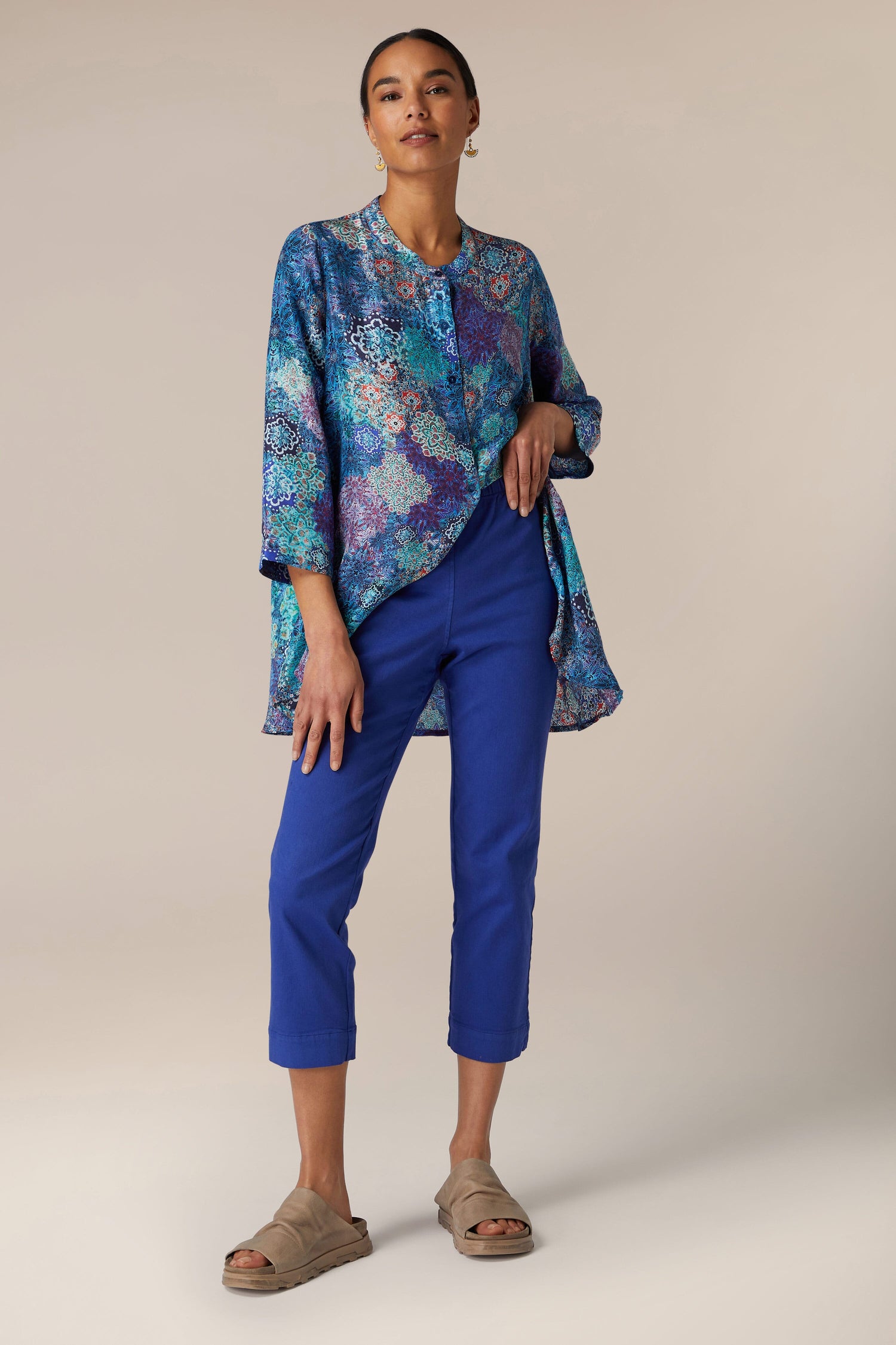 A woman in a blue patterned top and Stretch Cotton Slim Trouser stands against a neutral background.