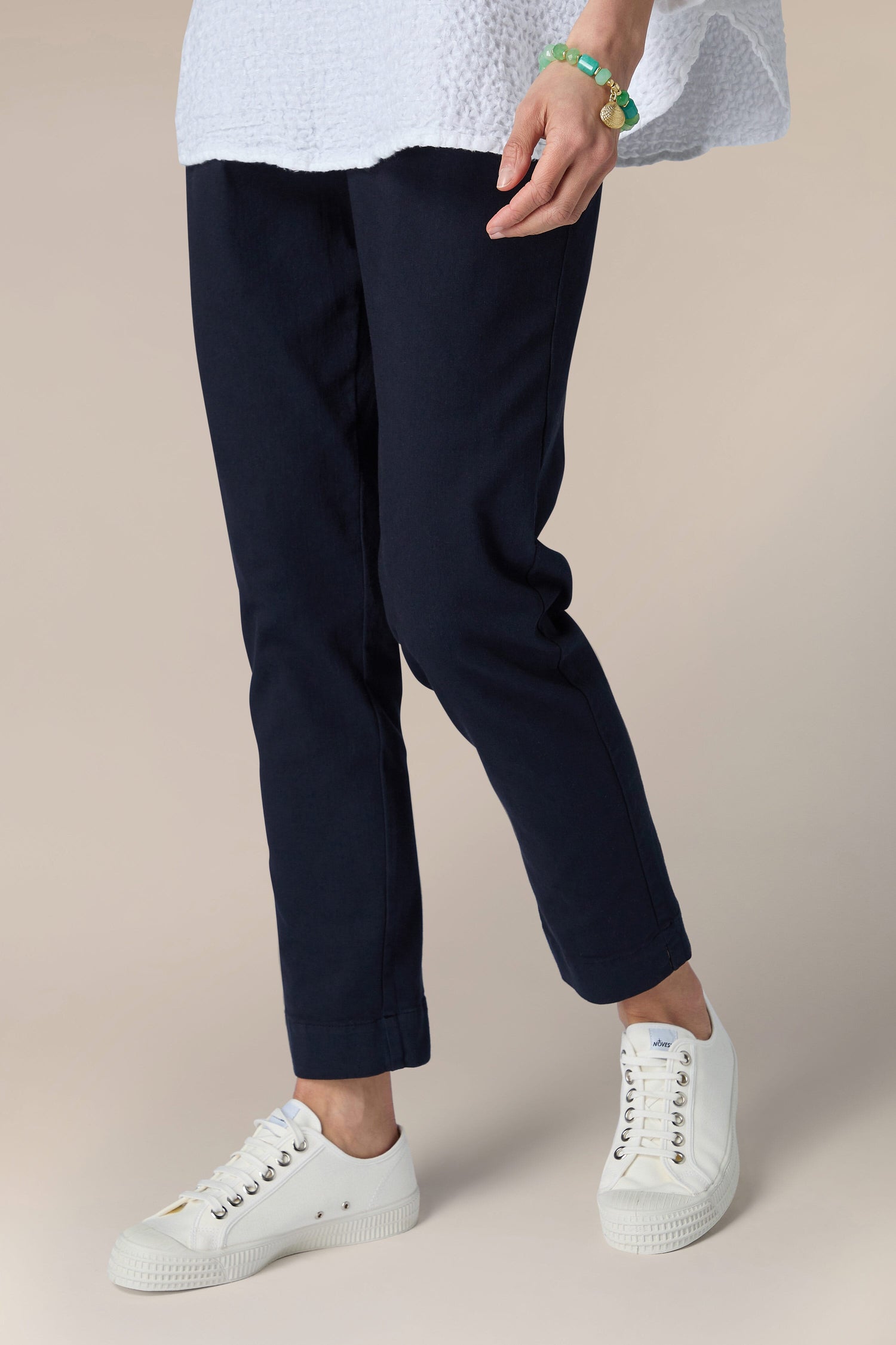 A woman wearing navy Stretch Cotton Slim Trousers and a versatile white shirt.