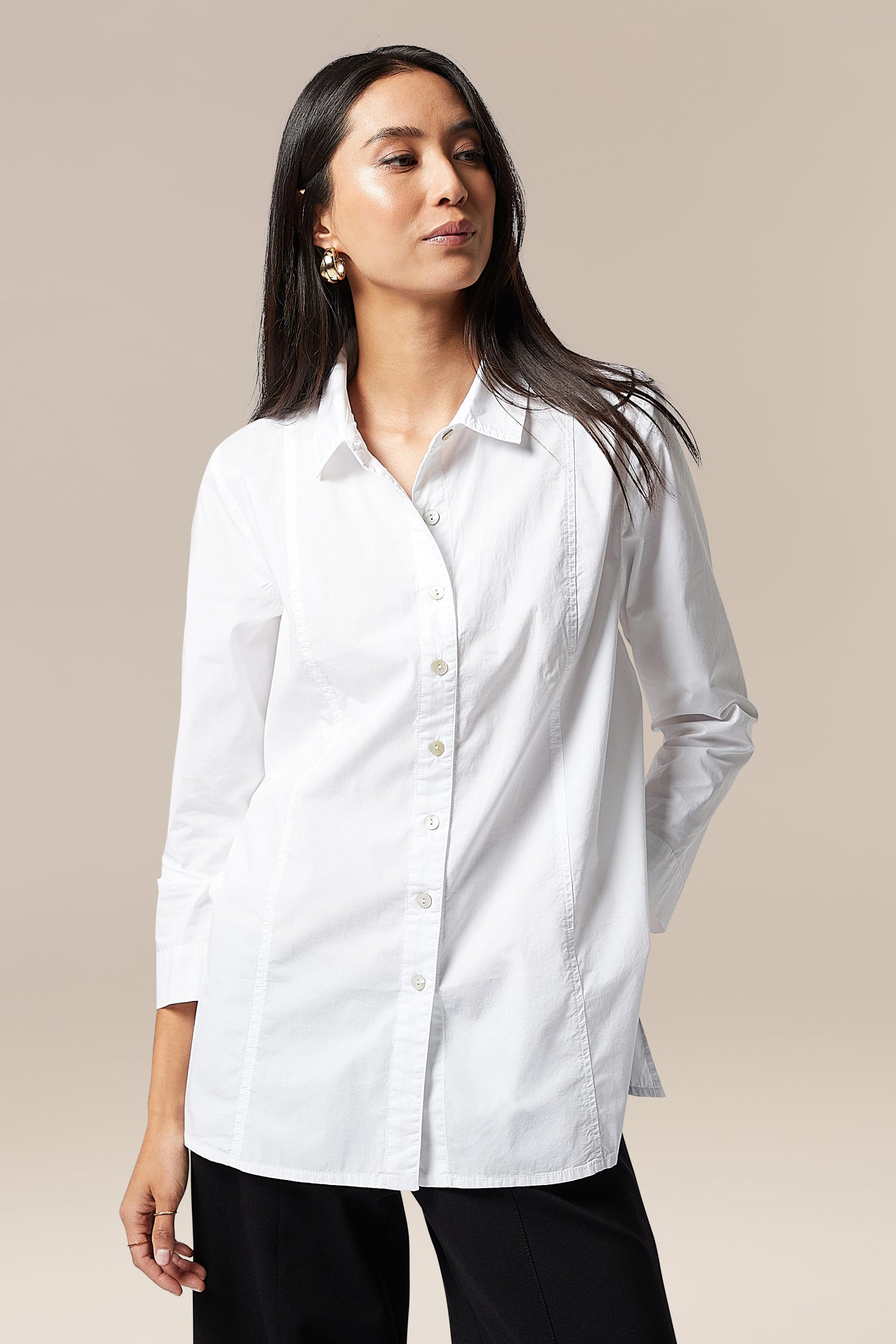 A woman wearing an elegant Paper Cotton Shirt and black pants.