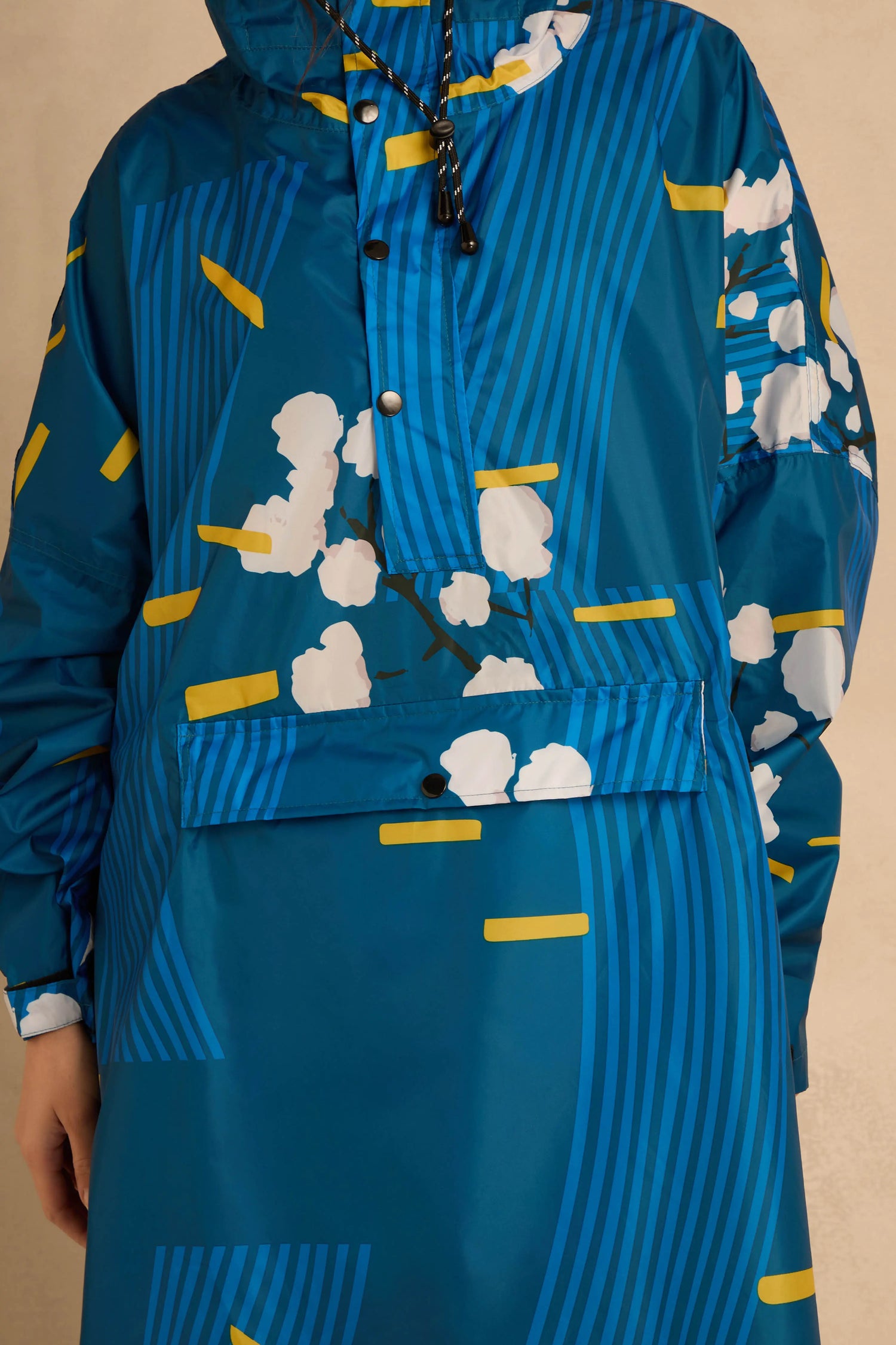 Japanese Blue Blossom Poncho featuring a blue base with a white floral pattern and yellow geometric accents.