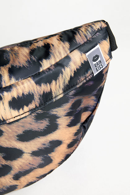 A close-up of the Dark Leopard Cross Body Bag, showing its dark leopard print and a "BIMBAYLOLA" brand tag attached to the zipper area.