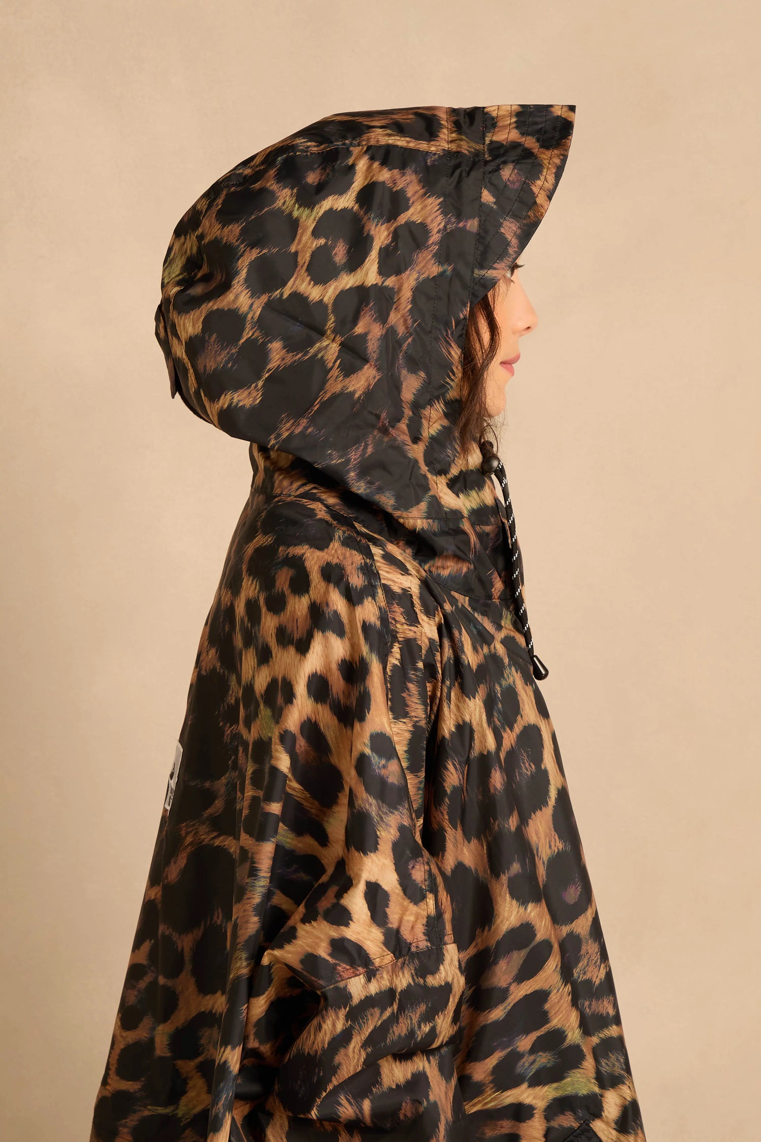 Side profile of a person wearing an oversized Dark Leopard Rain Coat.