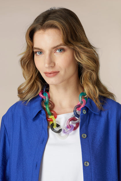 An eye-catching woman wearing a blue shirt and Rainbow Rings Necklace adorned with aluminium rings.