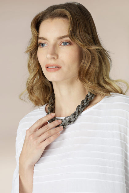 A woman wearing a white shirt and a Plaited Brass Necklace.