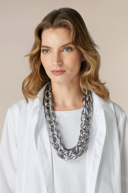 A woman wearing a white shirt and a Silver Woven Necklace with a lightweight design.