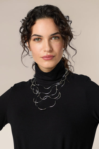 A woman wearing a black turtleneck and a Crescent Moons necklace.