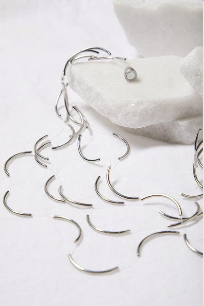 A Moon Necklace with a floating pearl in the middle.