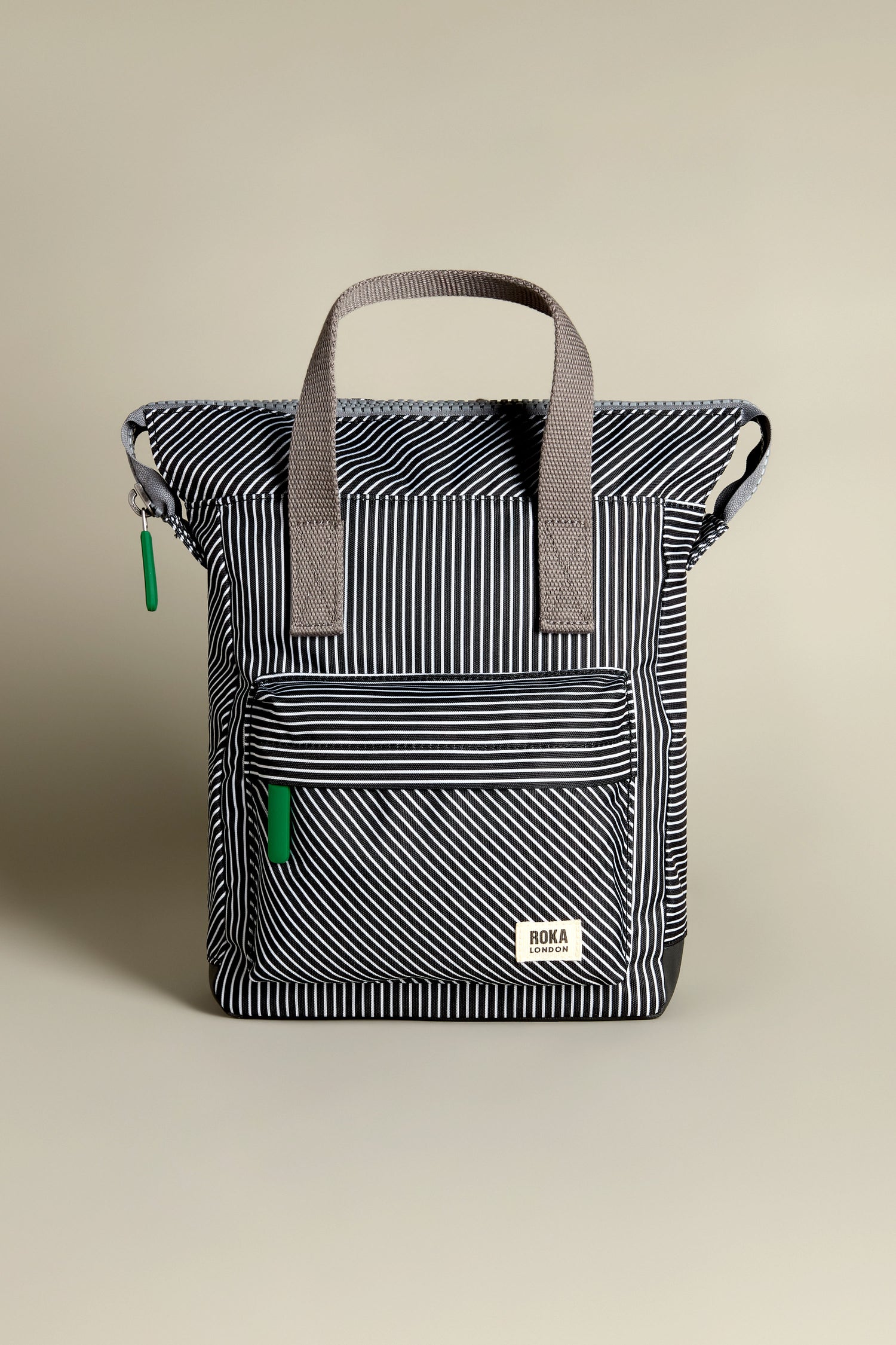 The Recycled Canvas Stripe Bantry Bag is a black and white striped backpack with gray handles and a front zipper pocket.