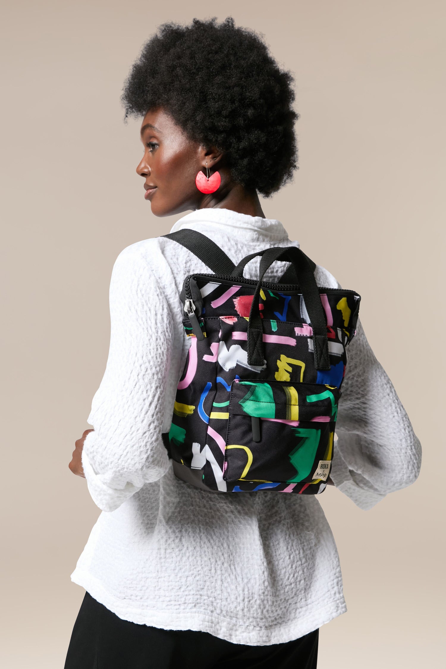 The back of a woman carrying a Recycled Scribble Print Bantry Bag made from recycled bottles.