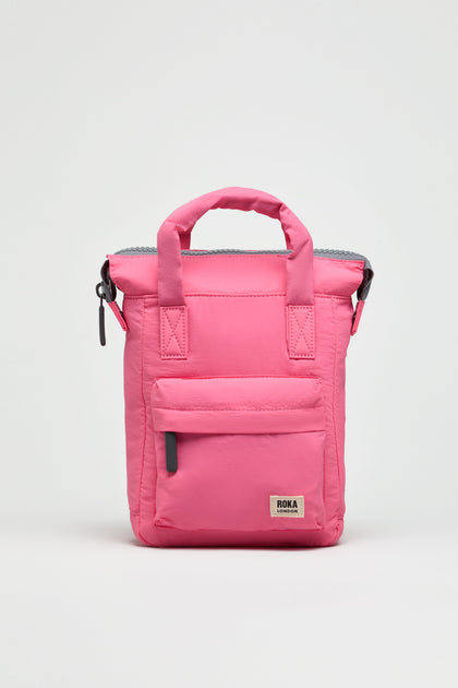 A compact, bright pink Recycled Mini Taslon Bantry Bag with a front zip pocket, short handles, and a logo patch displayed on a plain white background.