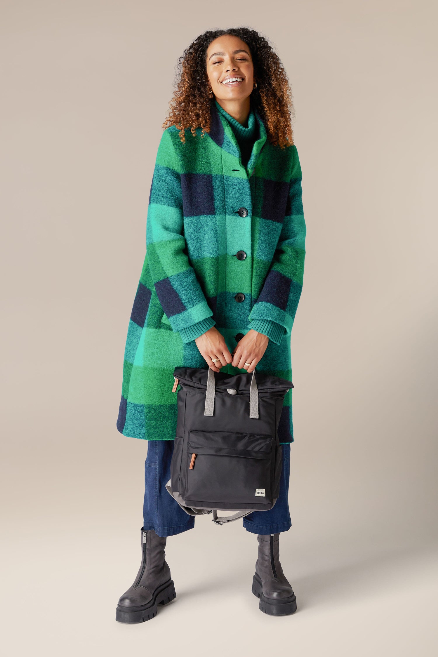 A woman wearing a weather-resistant Recycled Canfield Bag.