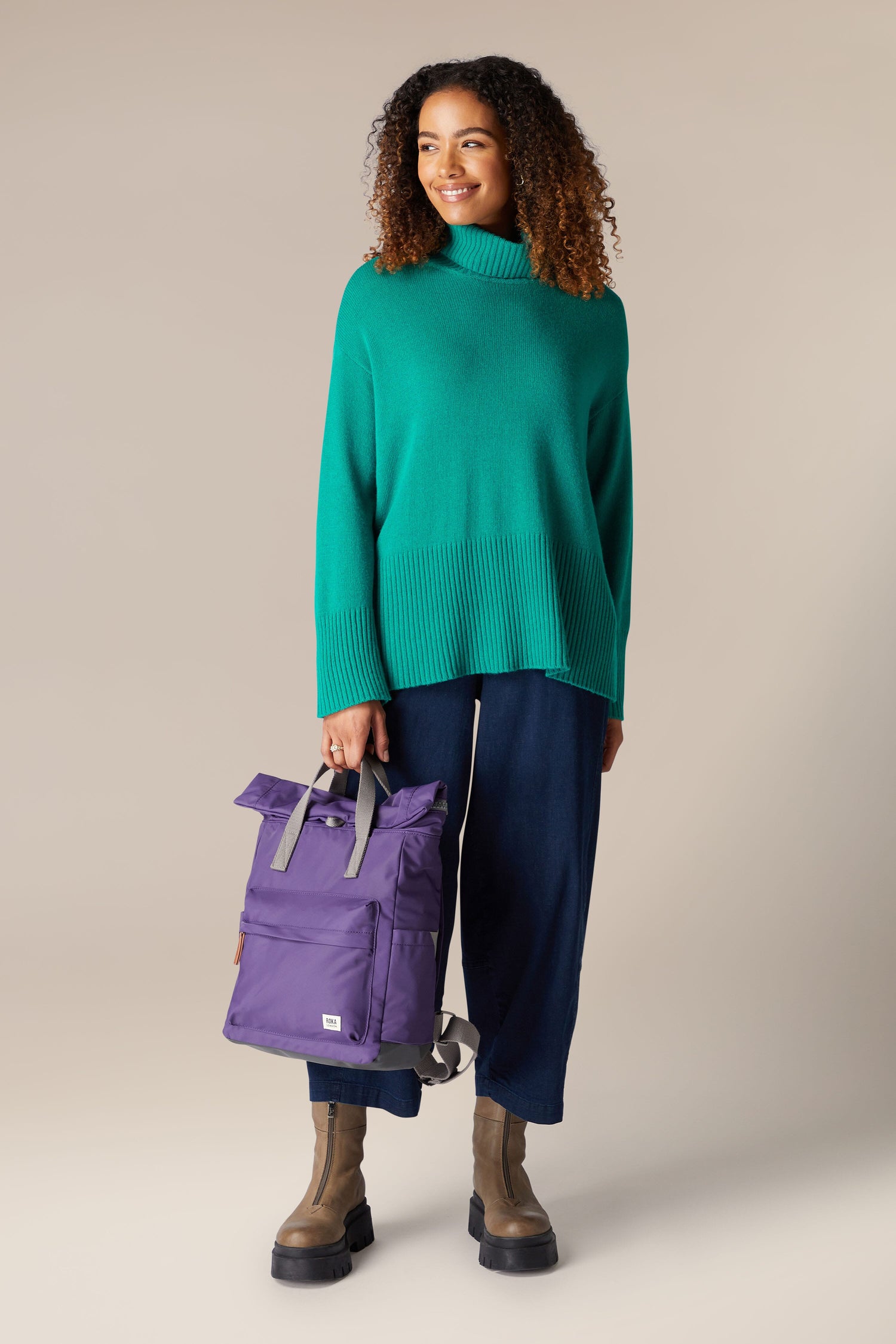 A woman is carrying a Recycled Canfield Bag.