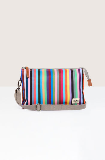 A Recycled Canvas Carnaby Crossbody Bag with a detachable strap, boasting vibrant stripes and weather-resistant material.