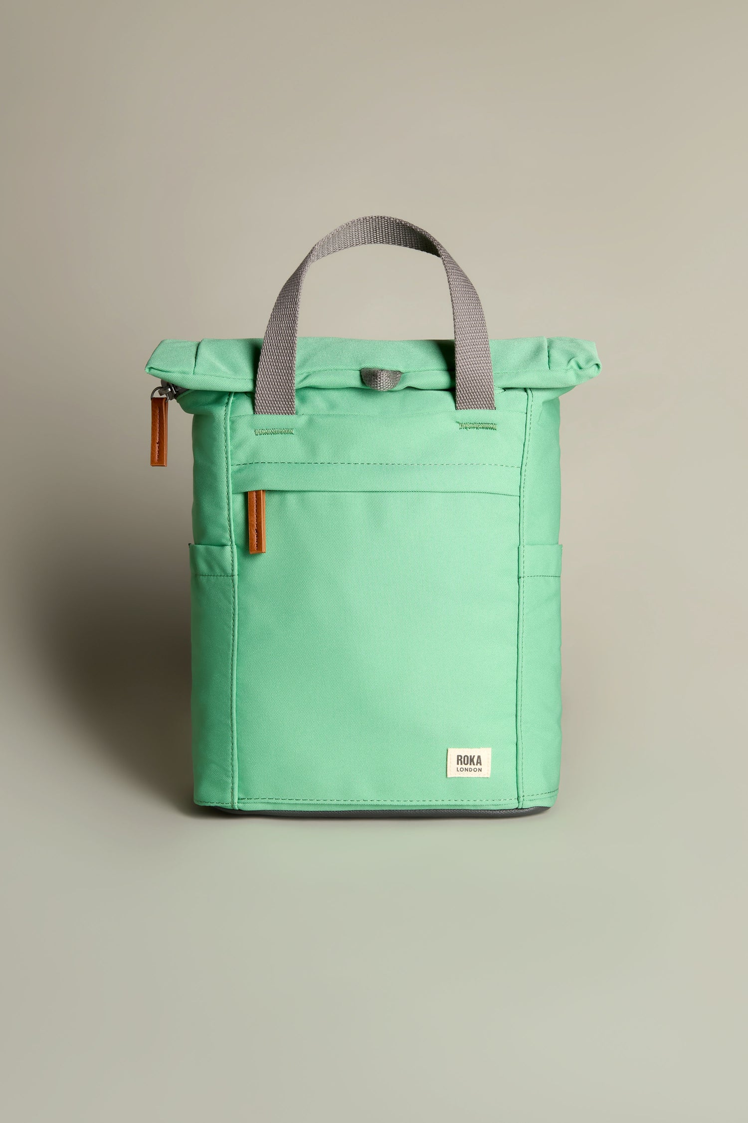 A mint green Recycled Canvas Small Finchley Bag with gray handles and zipper pulls is shown on a neutral background, highlighting its eco-friendly design.