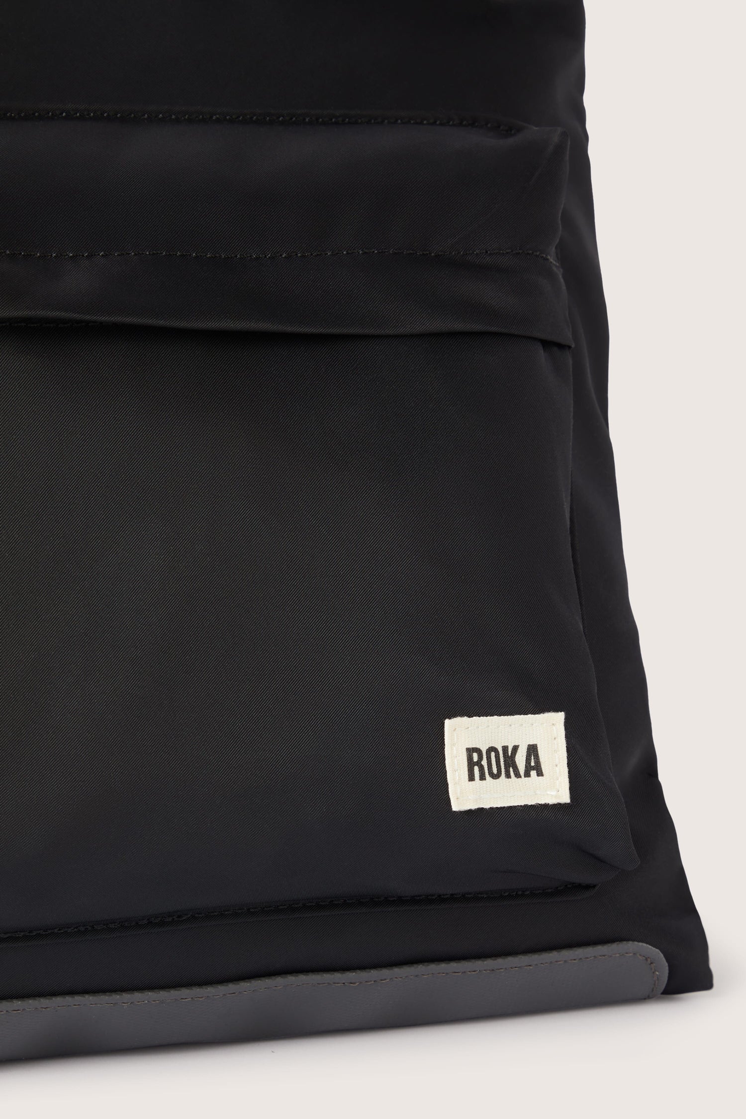 A weather-proof black Kennington Crossbody Bag with the word Rola on it.