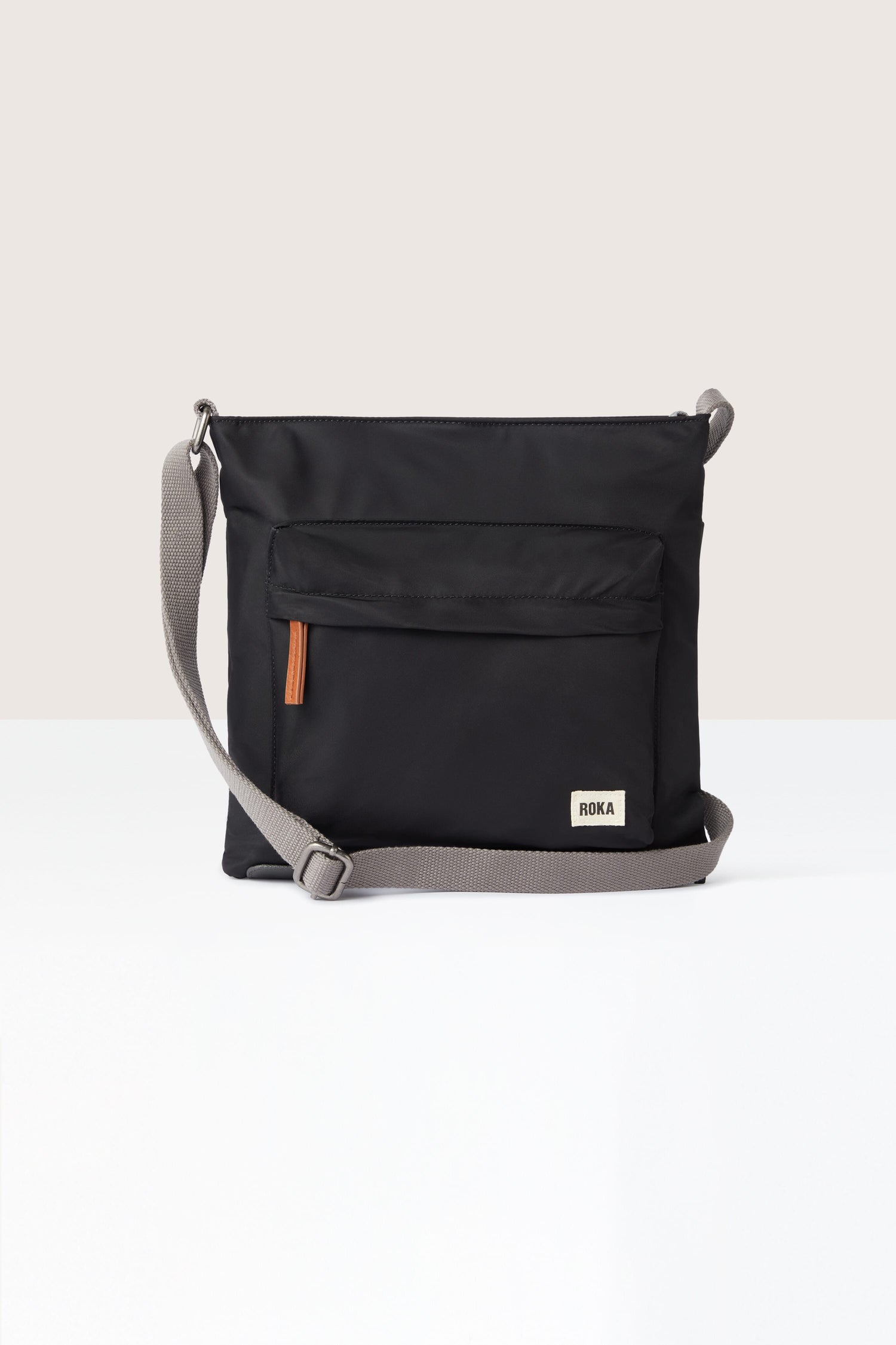 A sleek black Kennington Crossbody Bag with an adjustable strap on a white background.