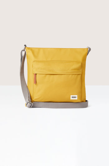 A sleek yellow Kennington Crossbody Bag with an adjustable strap on a white background.